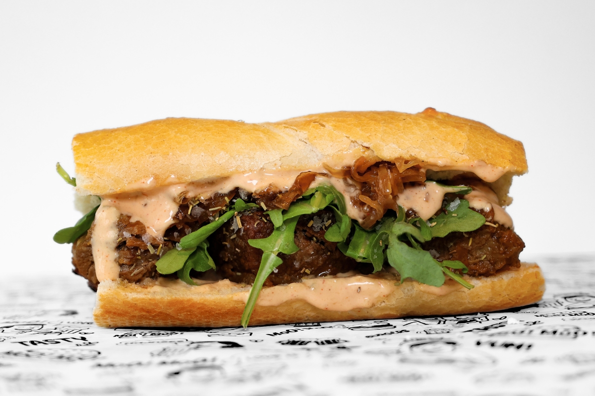 A MooMoo Burger sides bundle featuring golden thick-cut fries, and creamy coleslaw with crispy onions. Presented together on MooMoo Burger’s “Moo! Moo!” illustrated greaseproof paper in Hackney, London. Drinks also includes beers